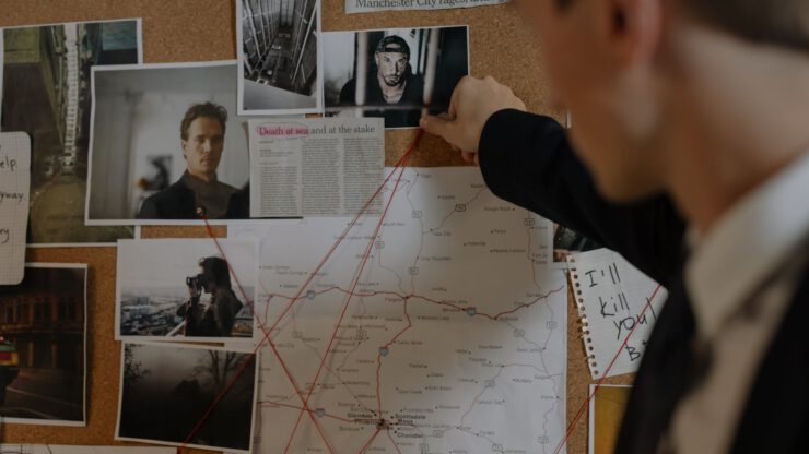man in black long sleeve suit looking at photographs on the wall